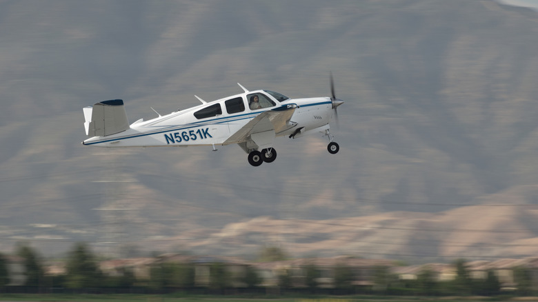 A 1964 Beechcraft S35 Bonanza takes off from a runway in Chino, California.