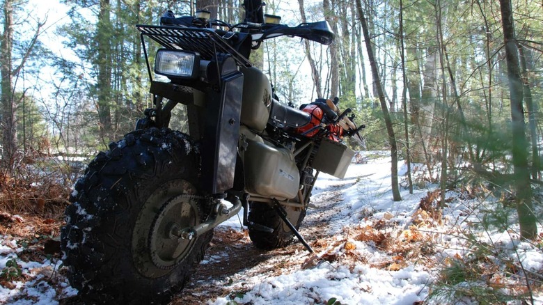 A green camoflage painted Rokon mototractor in the wilderness