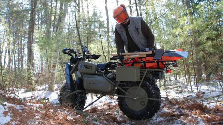A green camoflage painted Rokon mototractor in the wilderness