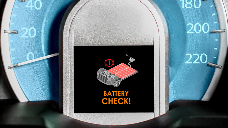A car dashboard showing a battery check warning sign.