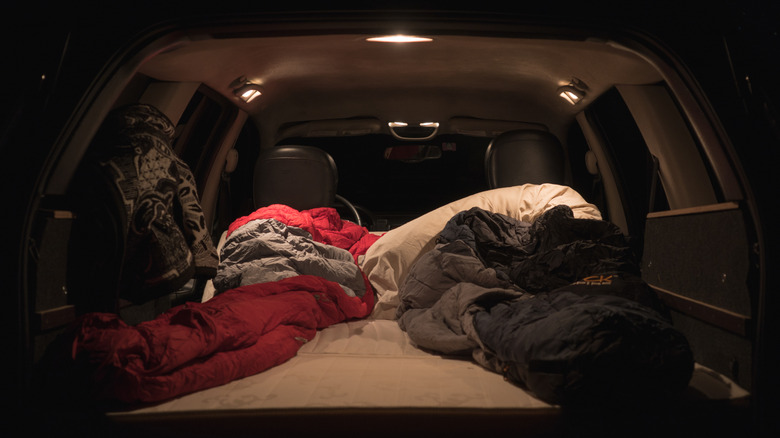 A simple car camping bedding setup, consisting of a thick mattress, good pillows, and sleeping bags.