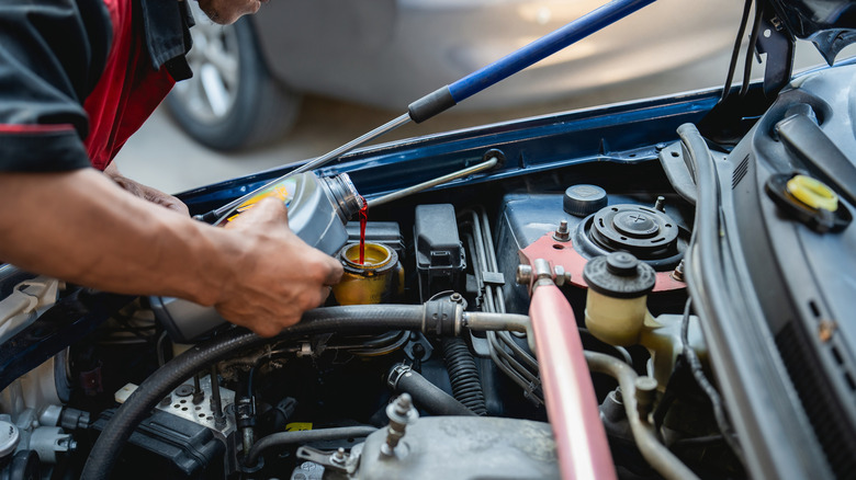Pouring hydraulic power steering fluid into a power steering reservoir
