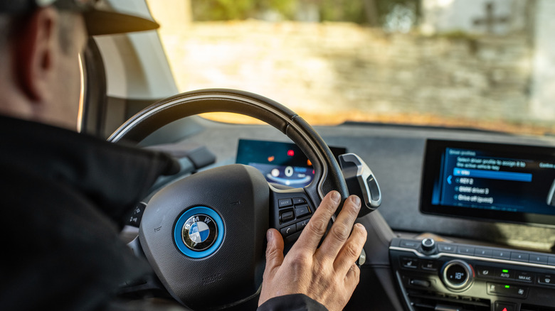 A man holding a car's steering wheel