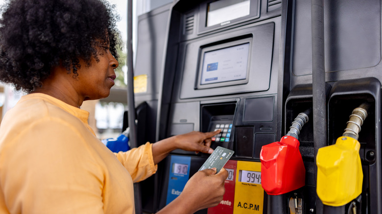 A customer paying at the gas pump with her card
