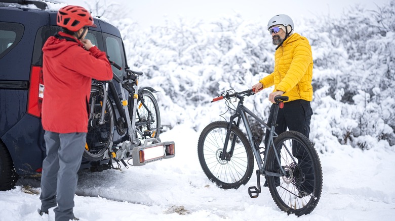 Cyclists loading bikes onto the back of a van