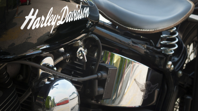 A closeup of a Harley-Davidson with plug wires and a springer solo seat