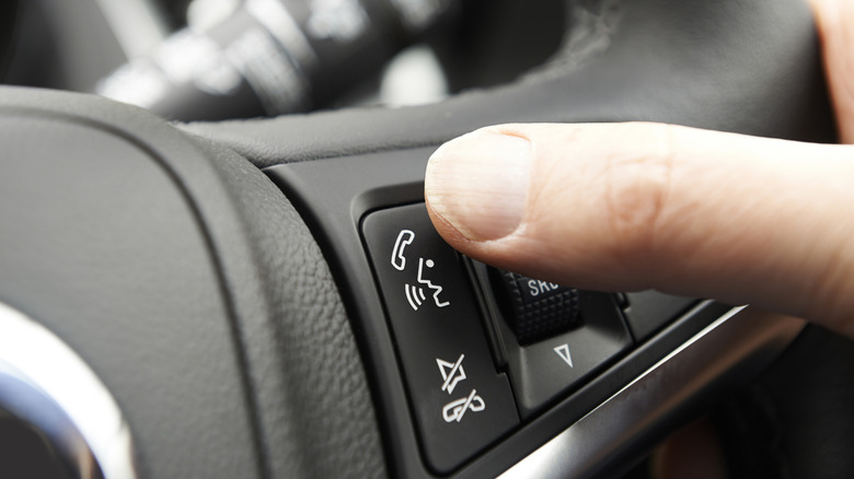 Person pressing steering wheel button