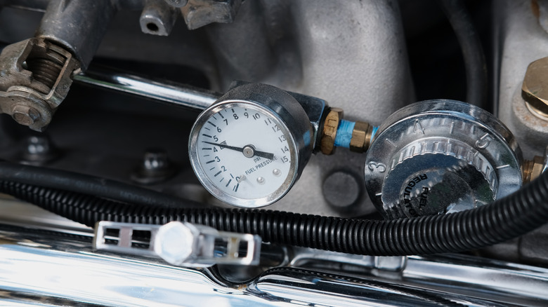 A fuel pressure guage under the hood of a car showing 4.5 psi.