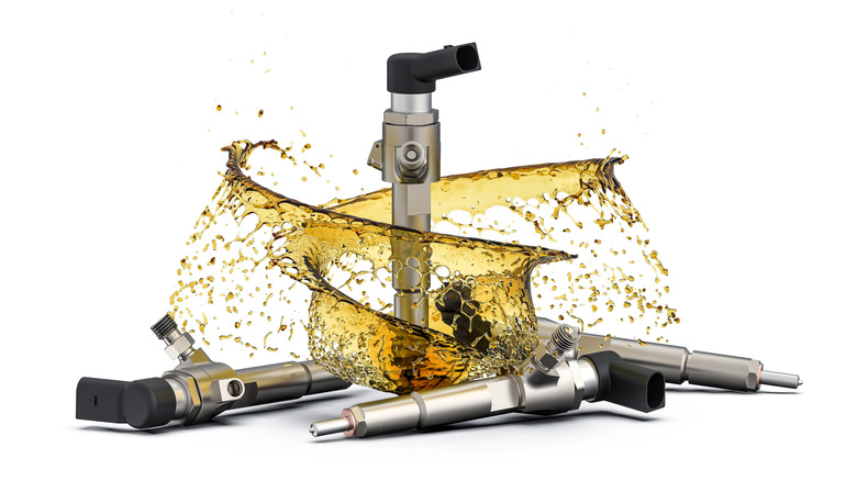 Fuel injectors standing up and laying down, with a swirl of fuel around them against a white background.