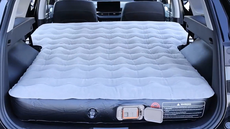 Inflatable mattress positioned in the back of an SUV