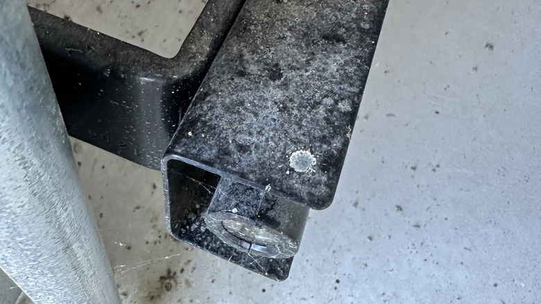 A close-up of a dirty garage door sensor