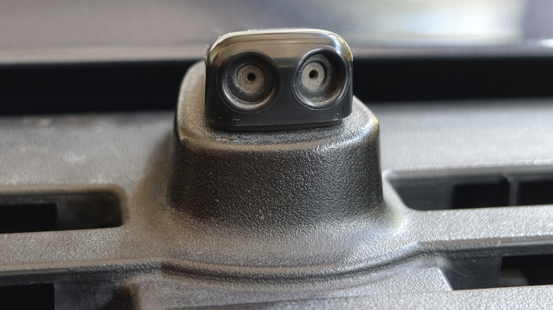 A closer view of a windshield washer nozzle of a car.