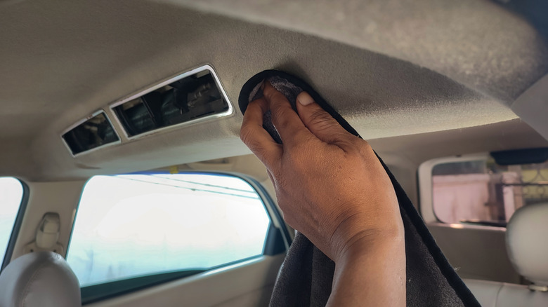 Man wiping the headliner with a cloth