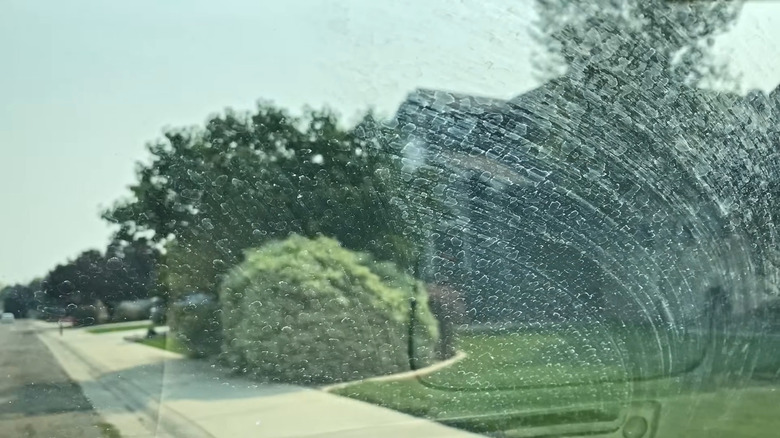 Water marks on a windshield, seen from inside the car.