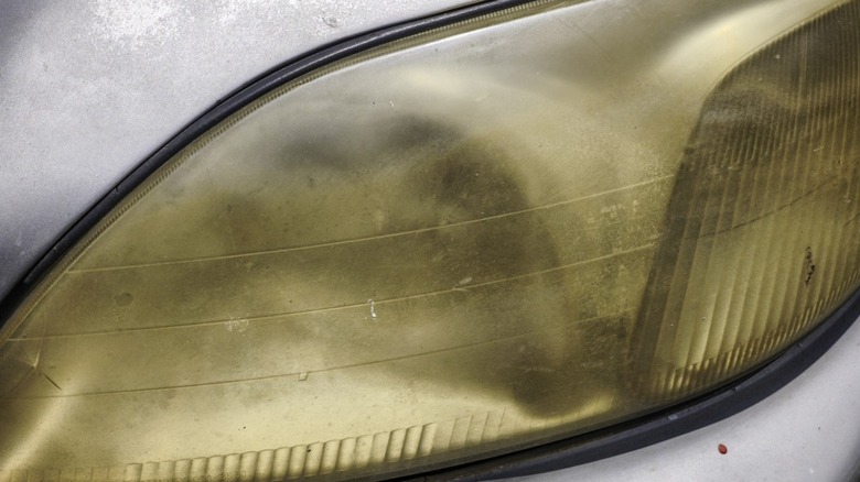 A car's headlight lens yellowed with age