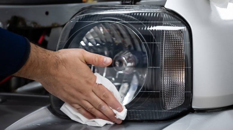 A closeup shot of a person's hand cleaning a headlight