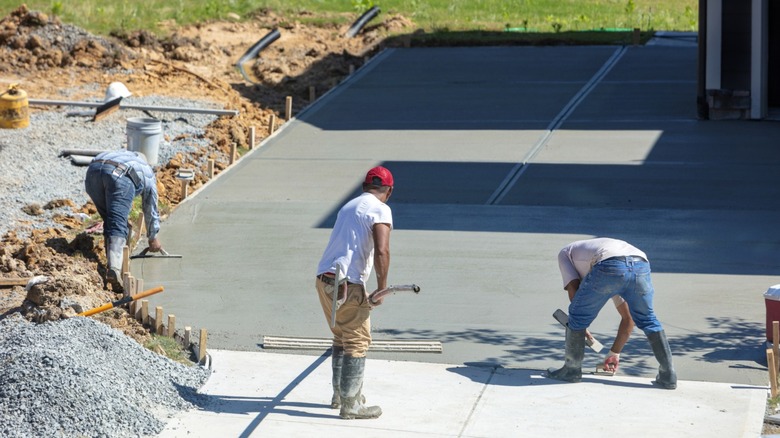 A group of people pouring a new concrete driveway