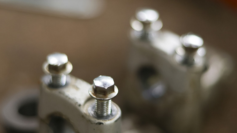 A metal engine cylinder head with shiny screws and bolts.