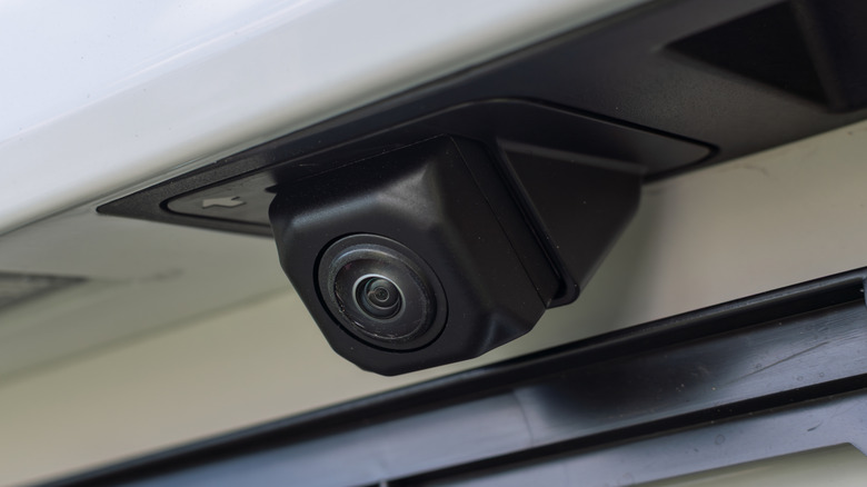 A close-up image of a car's backup camera mounted near the license plate