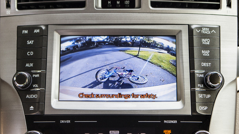 The center screen on a car's dashboard showing the view from behind the vehicle