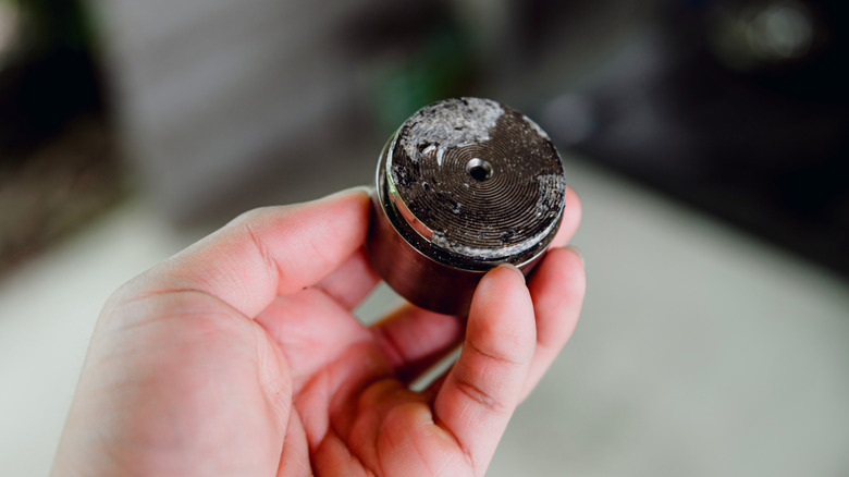 A person holding a corroded brake caliper piston