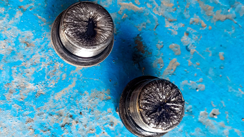Close-up view of a pair of used oil drain plugs