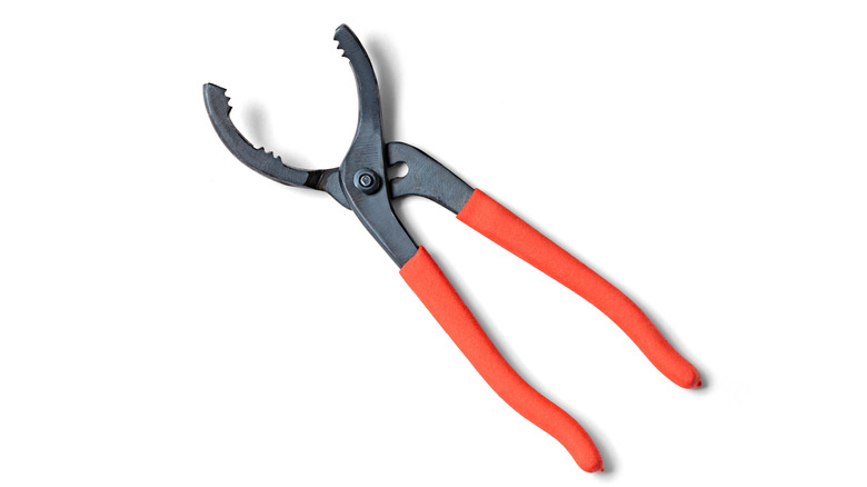Oil select pliers pinch a reddish handle.
