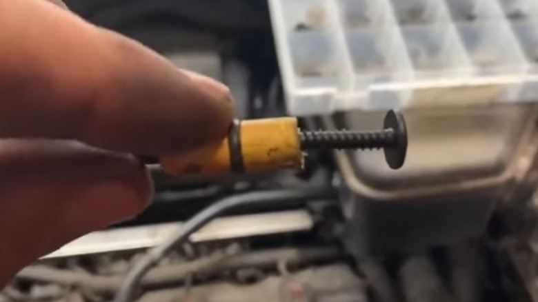 Using a screw to remove a broken oil dipstick.