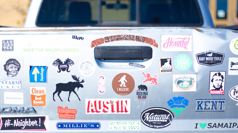 Silver truck tailgate covered in various bumper stickers