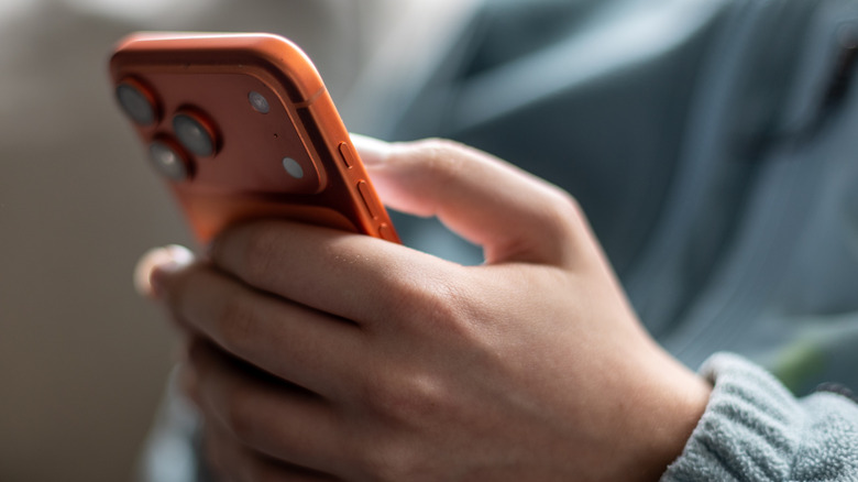 A person using an orange iPhone