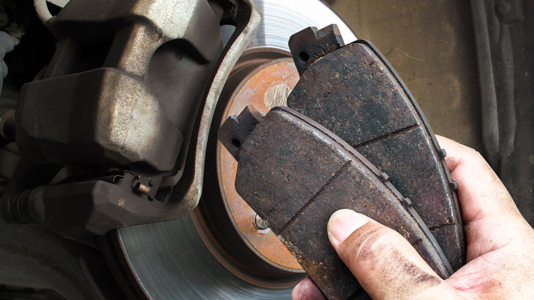 A hand holding car brake pads