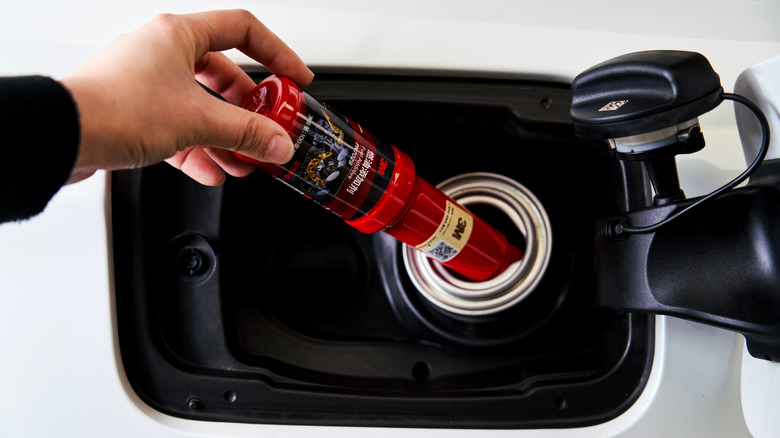 Person pouring fuel additive into the fuel tank