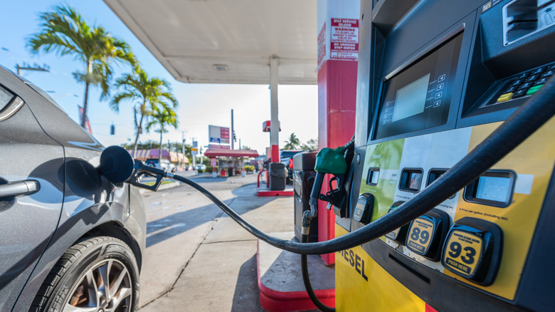 A gray car refueling at a gas station