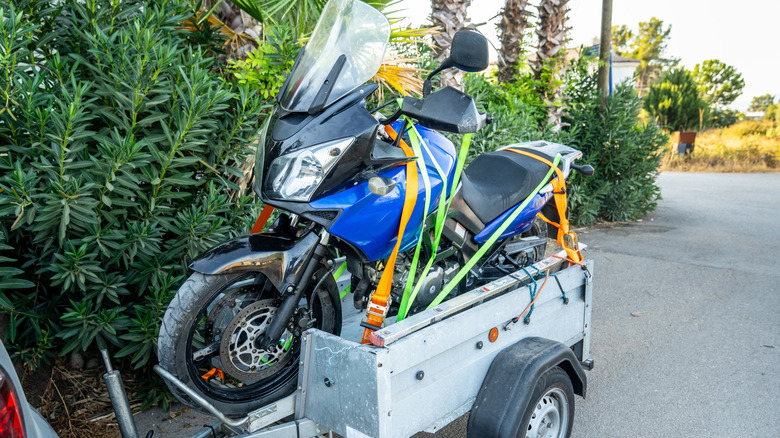 A motorcycle strapped down to a trailer