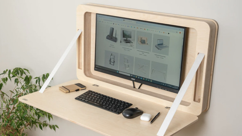 A fold-out wall desk hides a desktop computer screen.