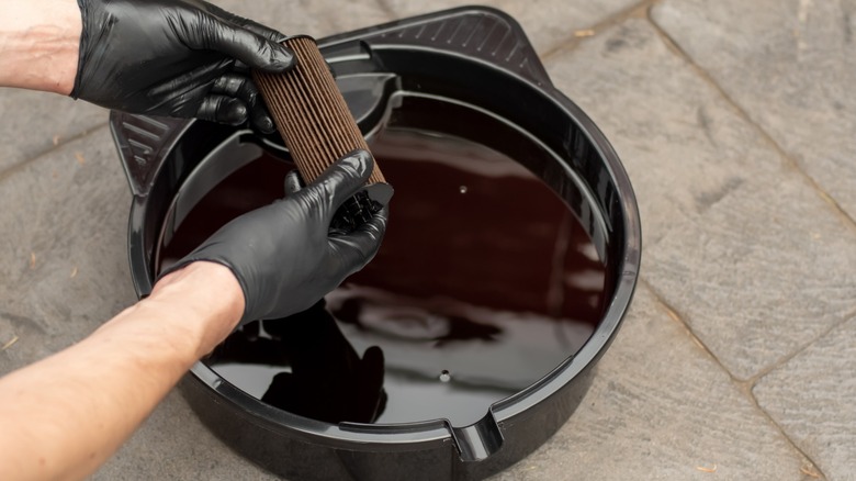 A pan filled with drained motor oil