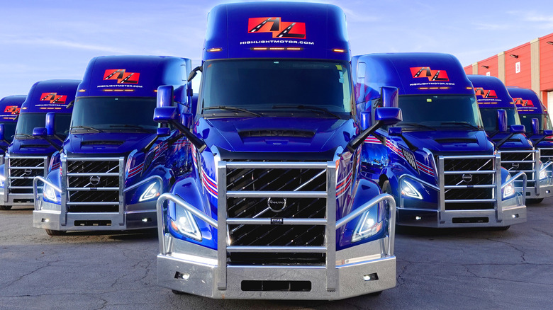 A fleet of Volvo VNL semi-trucks arranged in a V formation