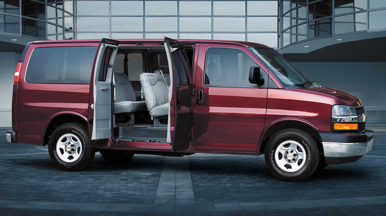 2003 Chevy Express parked in front of a building with its side doors open