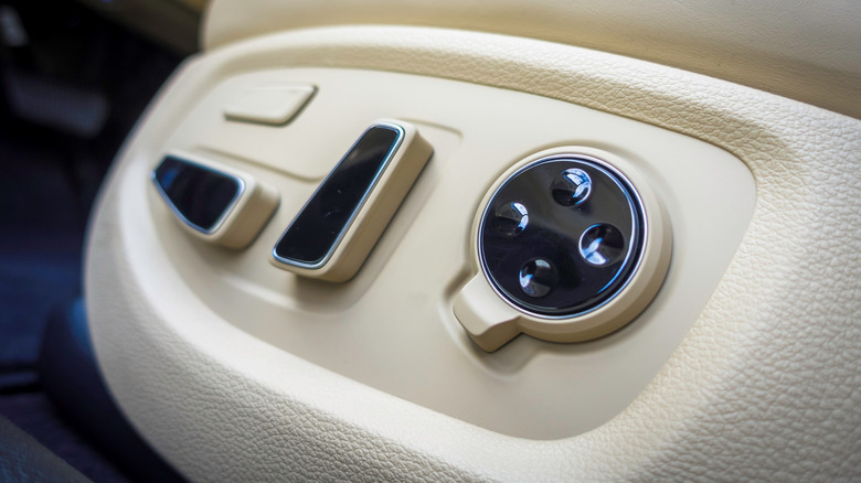 A close-up of the power seat controls in a Genesis G80 with a light tan interiorp