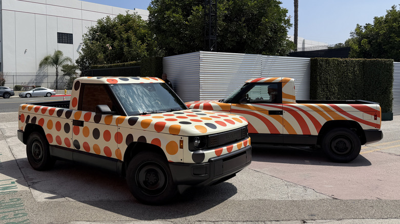 Two colorfully wrapped Slate trucks driving past each other