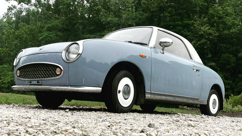 Blue Nissan Figaro parked in a lot
