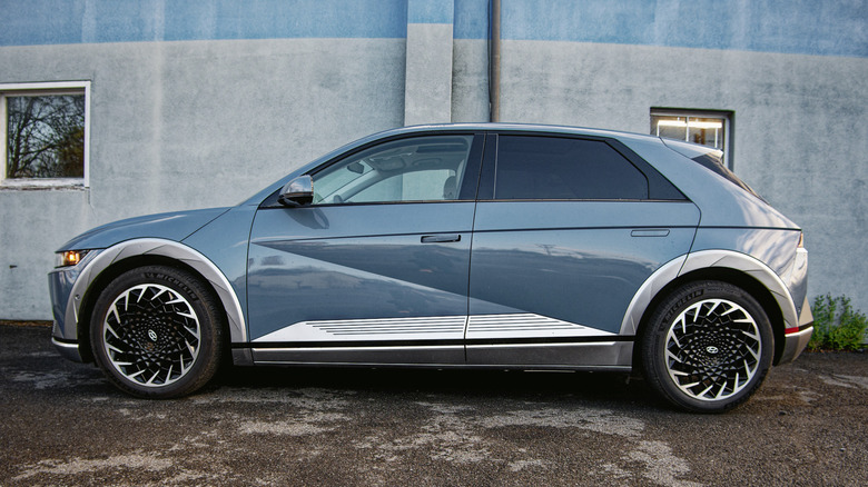 A Hyundai Ioniq 5 parked against a blue and gray wall.