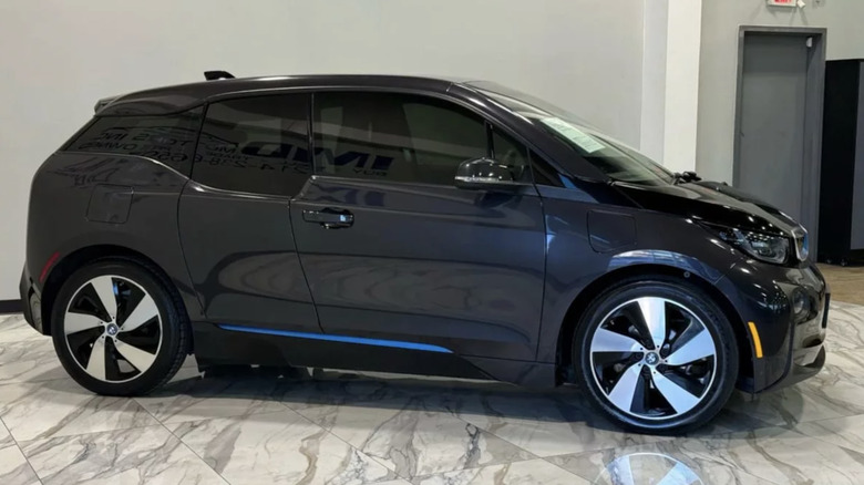 a blue BMW i3 parked inside on a marble floor