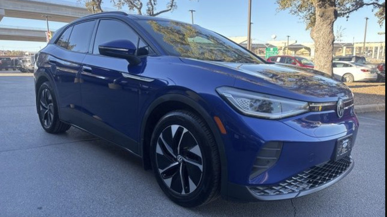 a blue Volkswagen ID4 parked on a dealer lot on a sunny day