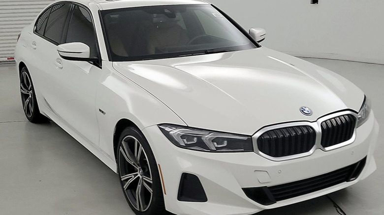 white 2023 BMW 330 Plug In Hybrid parked in a empty room