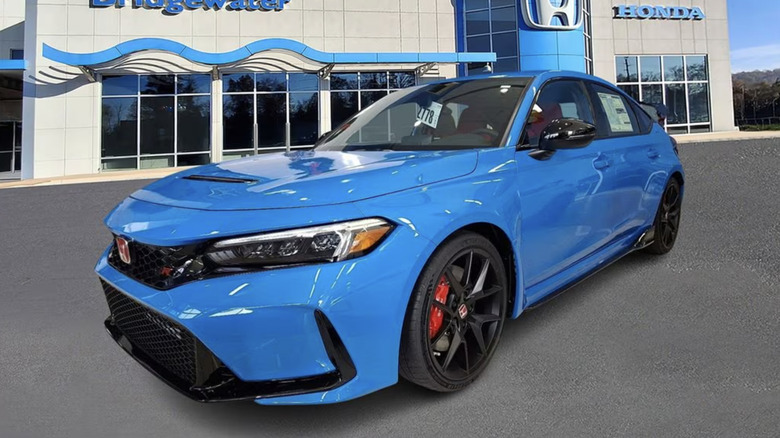 Honda Civic Type R in blue parked in front of a dealership