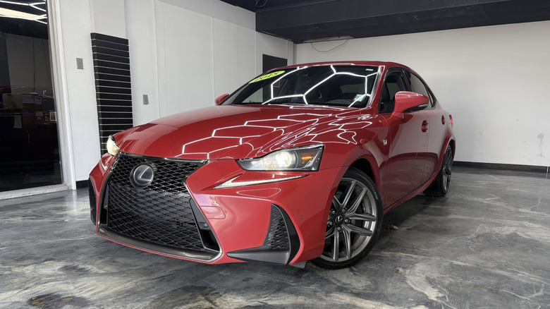 A red Lexus IS350 F-Sport parking inside on a cement floor