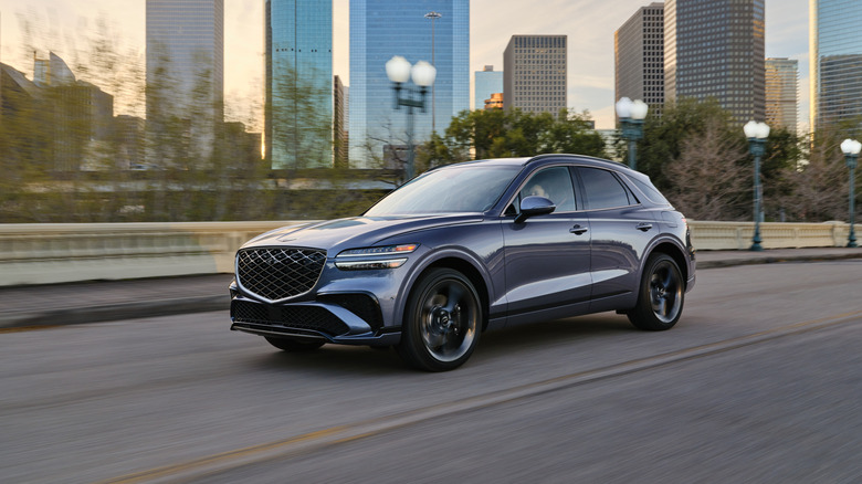 Genesis GV70 driving down a city street