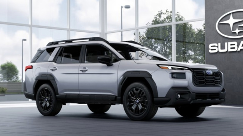 a silver subaru outback parked in a dealership showroom