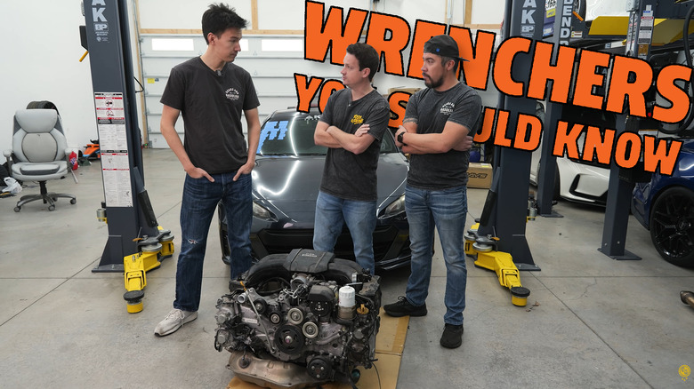 Ben, Ben, and Mark working on a Subaru